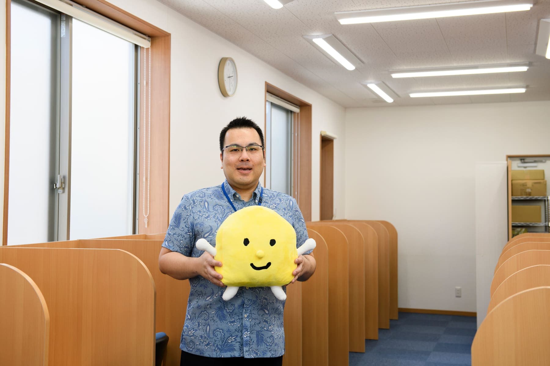 教室でマスコットのぬいぐるみを持つ宮里校責任者の川上一樹さん
