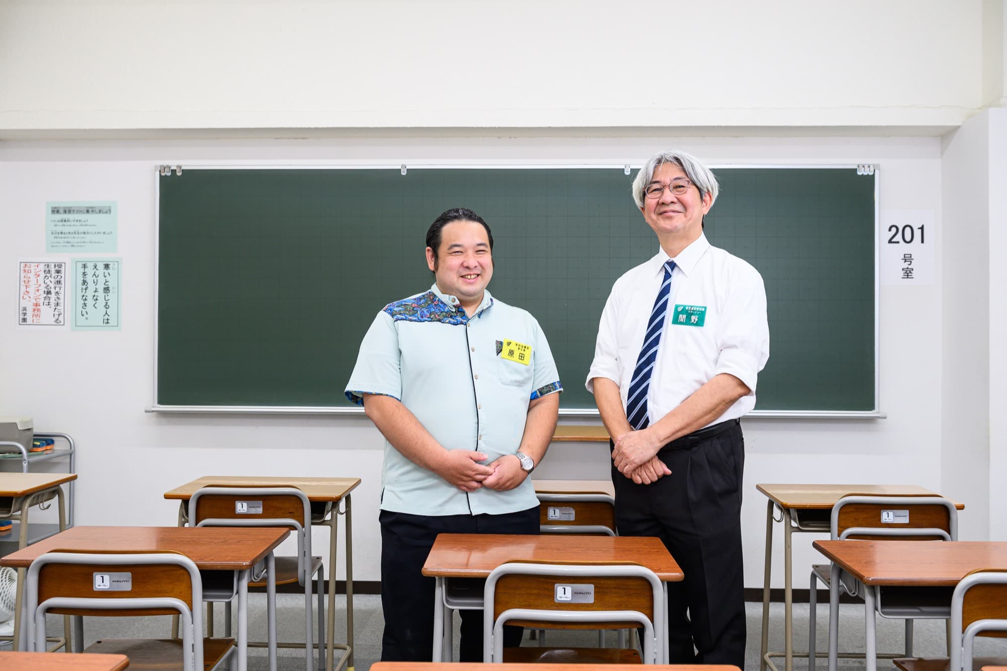 教室の黒板の前に並んで立つ原田雄太先生と間野正一さん