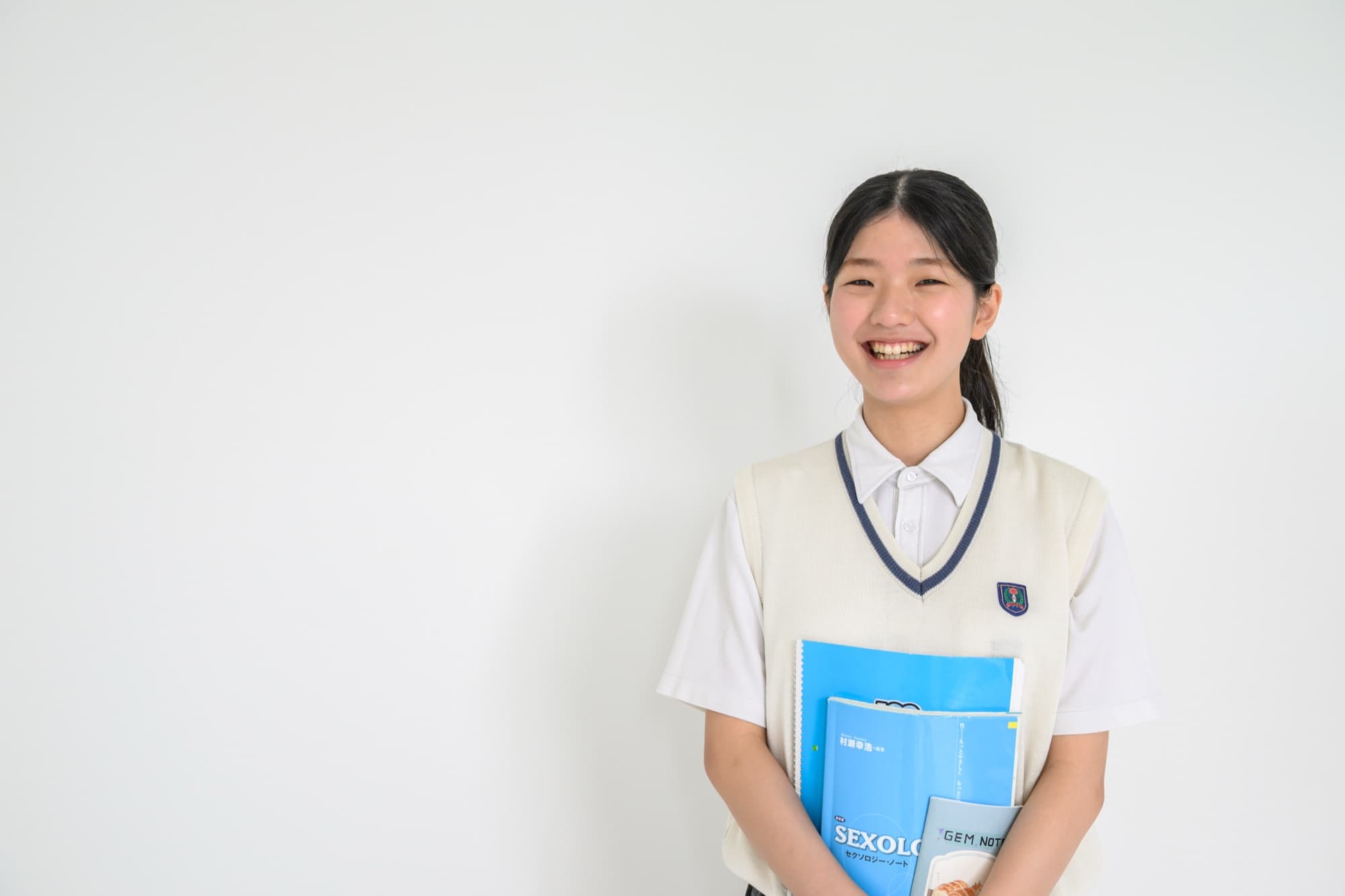 ノートを抱えて笑顔を見せる東恩納沙奈さん