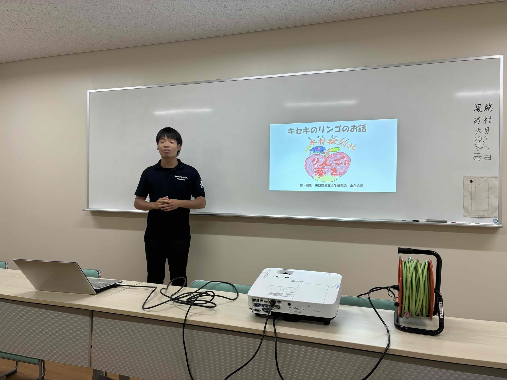 研修会でスクリーンの前に立って話す講師