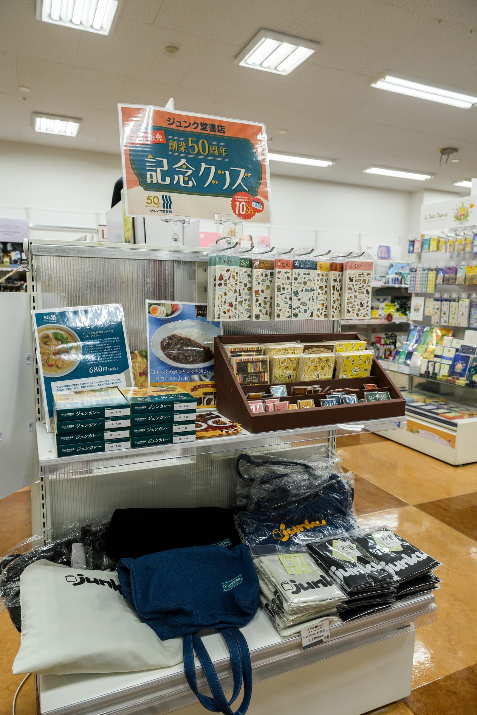 「ジュンク堂書店 創業50周年 記念グッズ」の看板の下に並ぶ記念グッズ