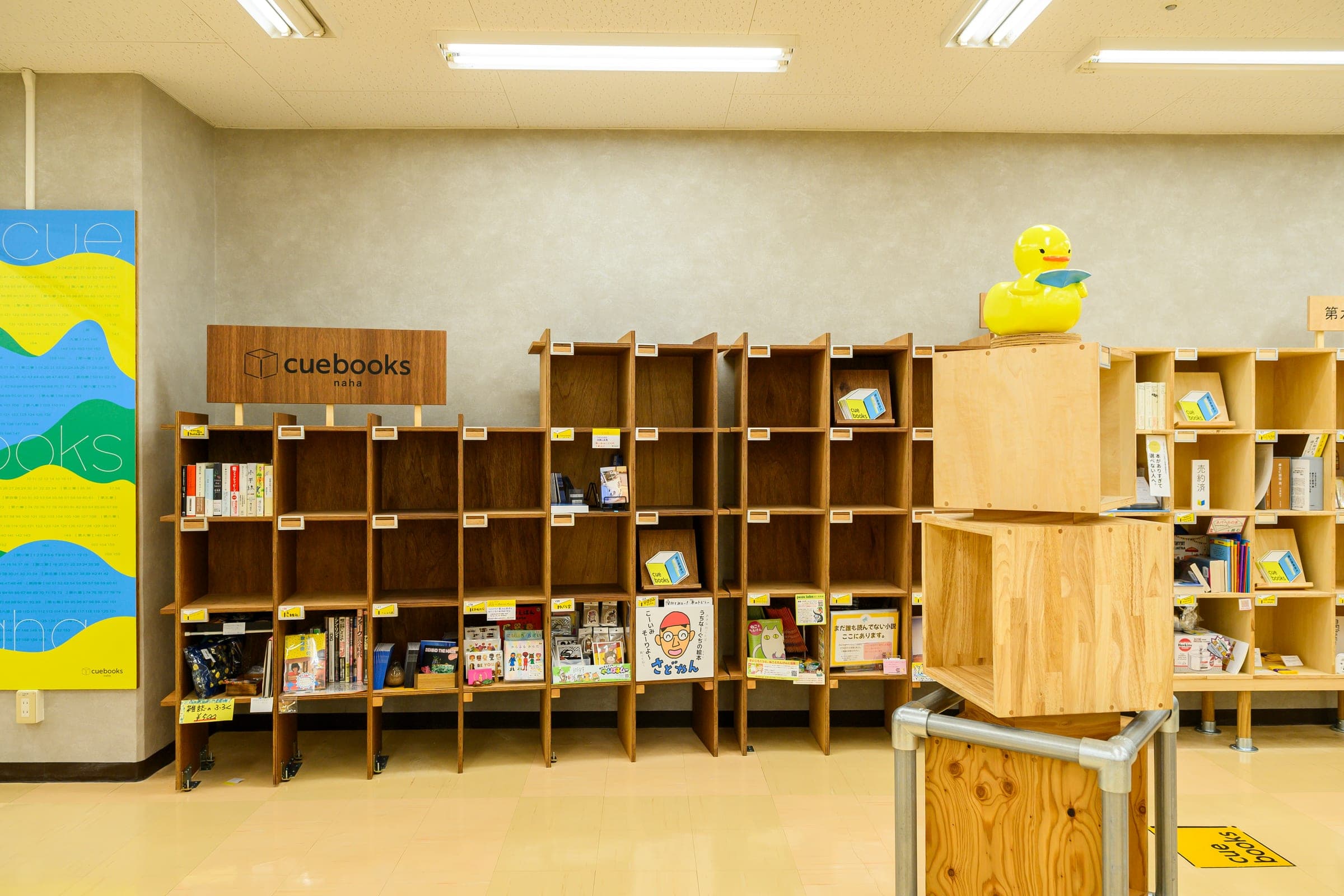 シェア本棚「cuebooks naha」の木製の棚が並ぶ売場