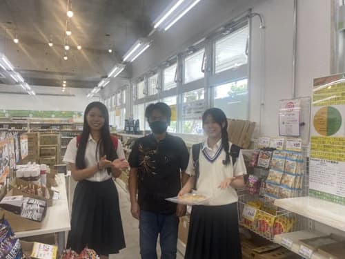 ecoeat 那覇与儀店の店内で、玉城淳一郎さんと並ぶ小禄高校の生徒2人