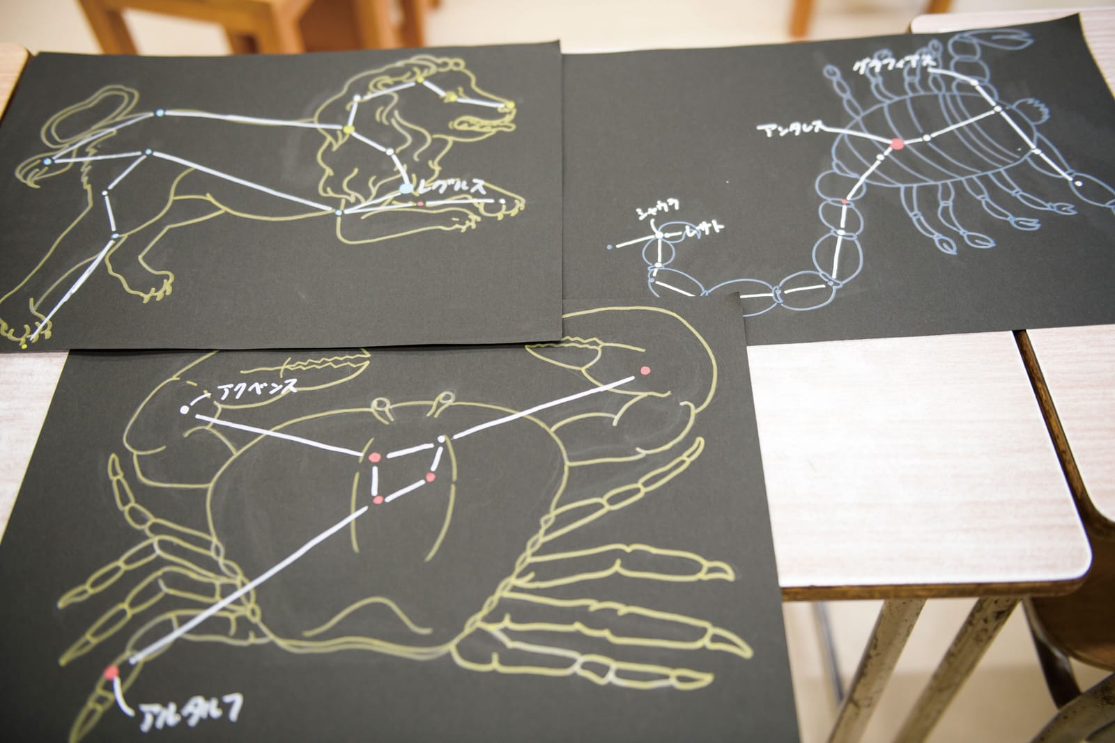 黒い紙に描かれた、しし座・さそり座・かに座の星座の絵